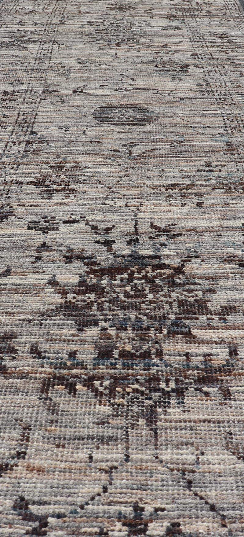Modern Oushak Designed Runner in Wool with Floral Design in Earthy Tones This modern casual tribal runner has been hand - knotted in wool. The runner features a modern sub - geometric floral design, and is enclosed within a complementary, multi - tie... - Keivan Woven ArtsAFG - 39879 - 19568Rug
