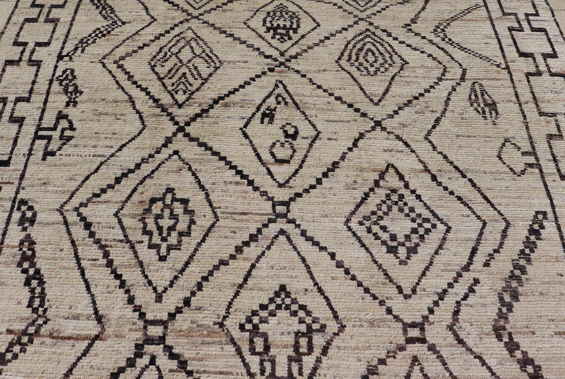 The design of the rug includes a series of interconnected diamond shapes, each containing different motifs such as crosses, zigzags, and other stylized symbols. The central theme is a grid of diamond patterns that vary slightly in size and detail, crea... - Keivan Woven ArtsAFG - 39925 - 19598Rug