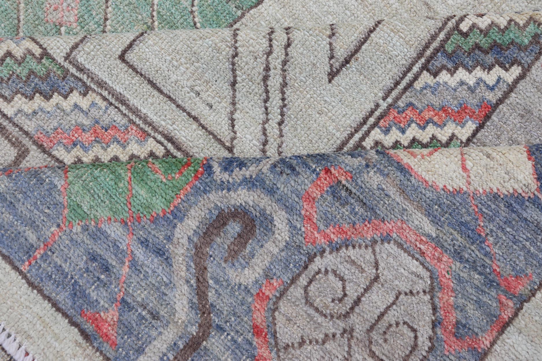 Finely hand knotted Khotan Rug with Circular Medallions in Shades of Purple, light Green, salmon, medium green and Cream. Keivan Woven Arts / rug AFG - 67298, country of origin / type: Afghanistan / Khotan. Measures: 9'8 x 13' This modern... - Keivan Woven ArtsAFG - 67298 - 24547Rugs