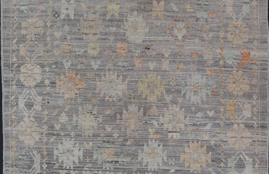 Modern Afghan Tribal Motif Designed Rug in Muted Tones and A Gray Background Measures 7'2 x 8'4 This modern area rug was hand - knotted in Afghanistan during the 2020's. This modern rug does feature a border of modest floral motifs. The gr... - Keivan Woven ArtsAFGC - 39487 - 18565Rug