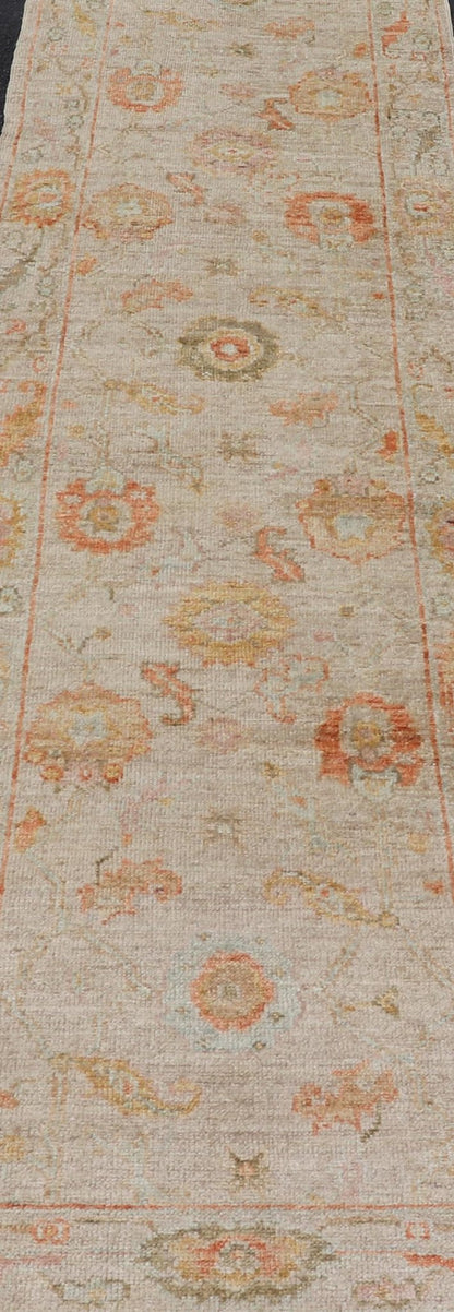 Angora Turkish Oushak Floral Runner in Cream with Pops of Orange, Green and Blue This angora Oushak is unique with is creamy background, to the floral like design rendered in coral, tangerine, forest green, salmon, and hints of sky blue. The bor... - Keivan Woven ArtsAN - 149531 - 19947Rug
