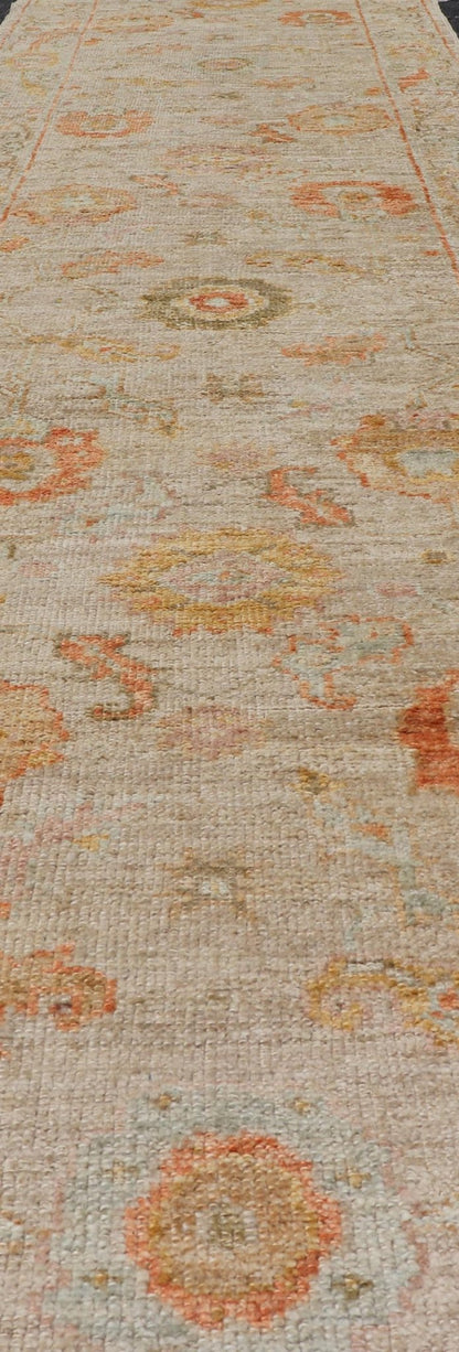 Angora Turkish Oushak Floral Runner in Cream with Pops of Orange, Green and Blue This angora Oushak is unique with is creamy background, to the floral like design rendered in coral, tangerine, forest green, salmon, and hints of sky blue. The bor... - Keivan Woven ArtsAN - 149531 - 19947Rug