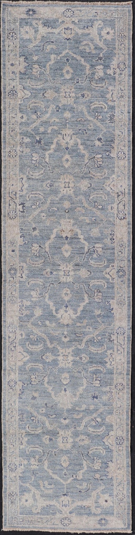 This Oushak Runner is rendered in a medium blue background and a light gray border. The design is an arabesque - like floral pattern, cased within a banded sub - floral border in light gray. Measures: 2'7 x 11'8 Angora Turkish Oushak Runner wit... - Keivan Woven ArtsAN - 151167 - 21391Rug