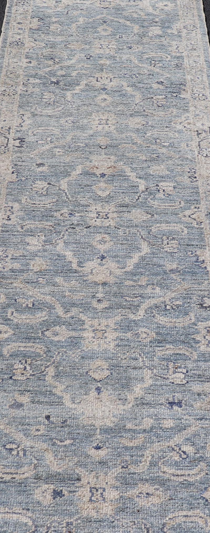 This Oushak Runner is rendered in a medium blue background and a light gray border. The design is an arabesque - like floral pattern, cased within a banded sub - floral border in light gray. Measures: 2'7 x 11'8 Angora Turkish Oushak Runner wit... - Keivan Woven ArtsAN - 151167 - 21391Rug