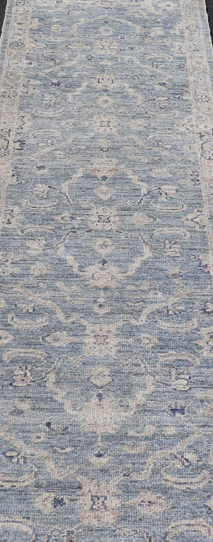 This Oushak Runner is rendered in a medium blue background and a light gray border. The design is an arabesque - like floral pattern, cased within a banded sub - floral border in light gray. Measures: 2'7 x 11'8 Angora Turkish Oushak Runner wit... - Keivan Woven ArtsAN - 151167 - 21391Rug