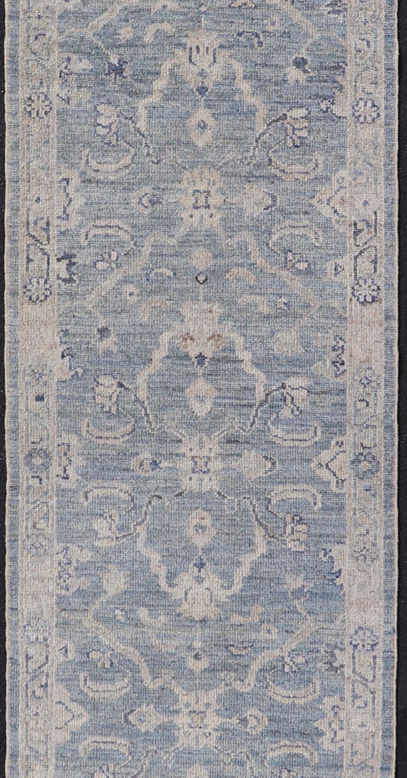 This Oushak Runner is rendered in a medium blue background and a light gray border. The design is an arabesque - like floral pattern, cased within a banded sub - floral border in light gray. Measures: 2'7 x 11'8 Angora Turkish Oushak Runner wit... - Keivan Woven ArtsAN - 151167 - 21391Rug
