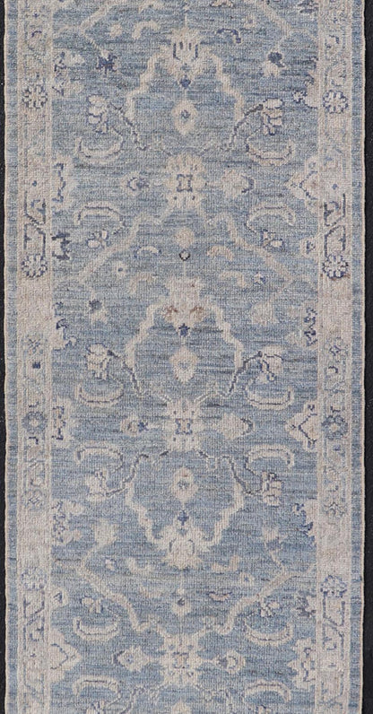 This Oushak Runner is rendered in a medium blue background and a light gray border. The design is an arabesque - like floral pattern, cased within a banded sub - floral border in light gray. Measures: 2'7 x 11'8 Angora Turkish Oushak Runner wit... - Keivan Woven ArtsAN - 151167 - 21391Rug