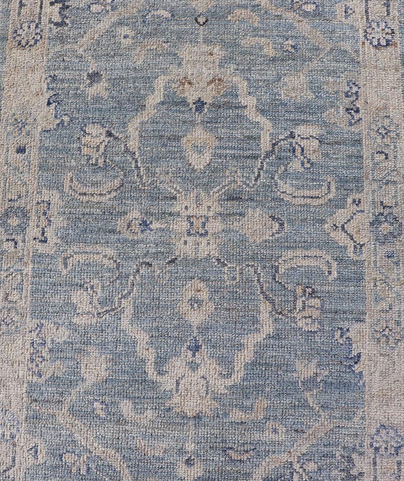 This Oushak Runner is rendered in a medium blue background and a light gray border. The design is an arabesque - like floral pattern, cased within a banded sub - floral border in light gray. Measures: 2'7 x 11'8 Angora Turkish Oushak Runner wit... - Keivan Woven ArtsAN - 151167 - 21391Rug