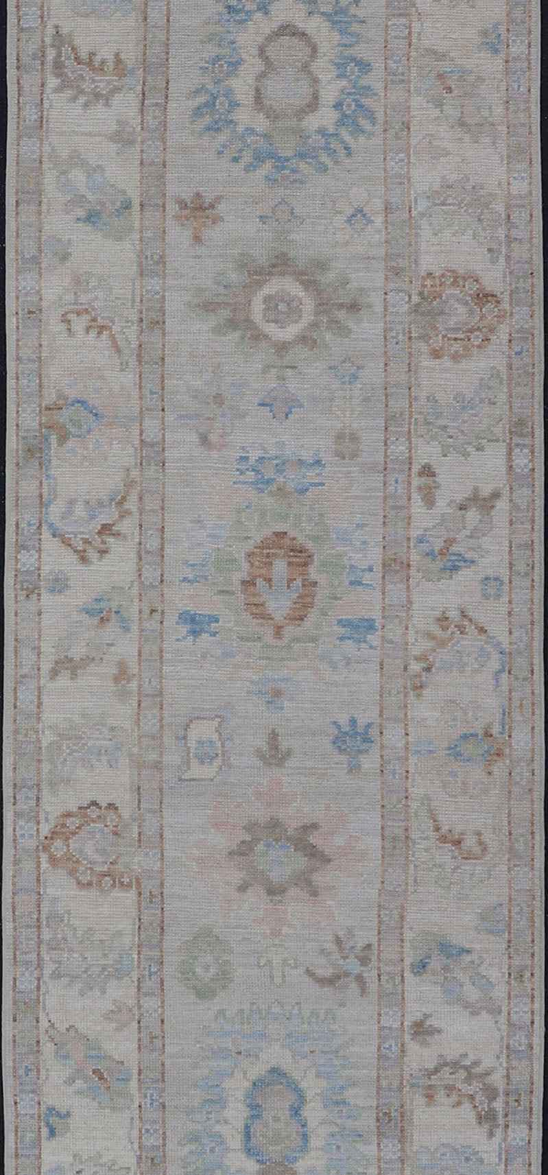 Measures: 3'1 x 12'3 Modern Oushak Runner on Light Cream Field and Colorful Motifs Of Blue & Green. Keivan Woven Arts; rug AWR - 12500 Country of Origin: Afghanistan Type: Oushak Design: Floral, All - Over Floral 21st Century This Oushak runner... - Keivan Woven ArtsAWR - 12500 - 23300Rug