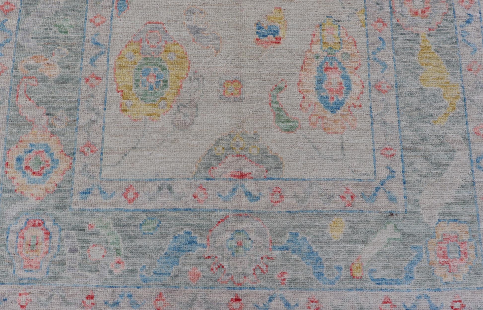 Modern All - Over Floral Oushak with Muted Background and Accent Colors Modern Oushak featuring an all - over, arabesque - like floral design, rendered in saturated oceanic blue, gold, green, red, and red - orange. The background is rendered in a co... - Keivan Woven ArtsAWR - 356 - 19959Rug