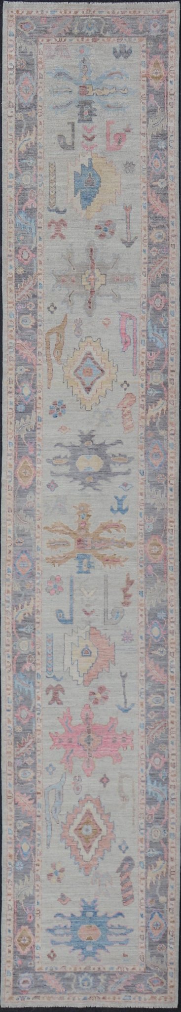 Hand - Knotted Modern Tribal Oushak Long Runner in Wool with Colorful Motifs This long Oushak runner has a cream background with a light gray border. The border has a leaflet - like design is rendered in green, coral, and blue with a hint of ye... - Keivan Woven ArtsAWR - 6026 - 19965Rug
