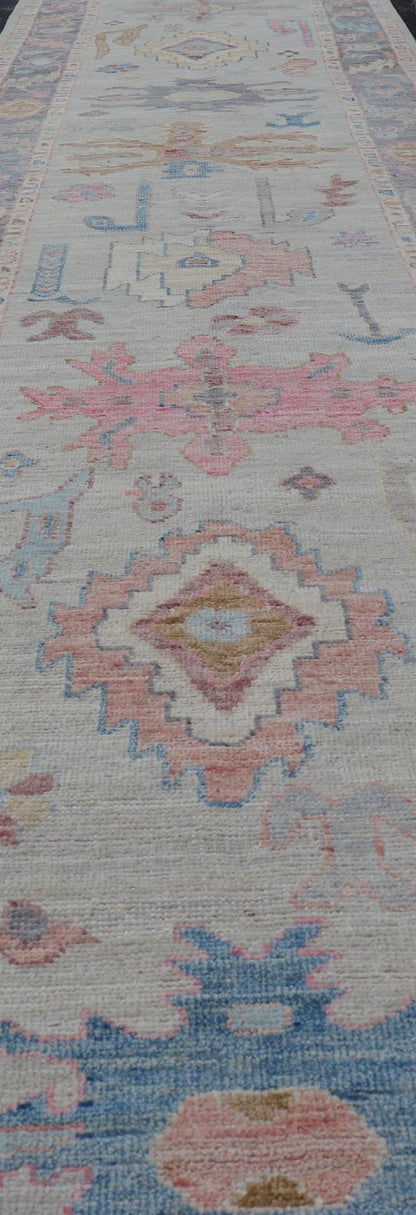 Hand - Knotted Modern Tribal Oushak Long Runner in Wool with Colorful Motifs This long Oushak runner has a cream background with a light gray border. The border has a leaflet - like design is rendered in green, coral, and blue with a hint of ye... - Keivan Woven ArtsAWR - 6026 - 19965Rug