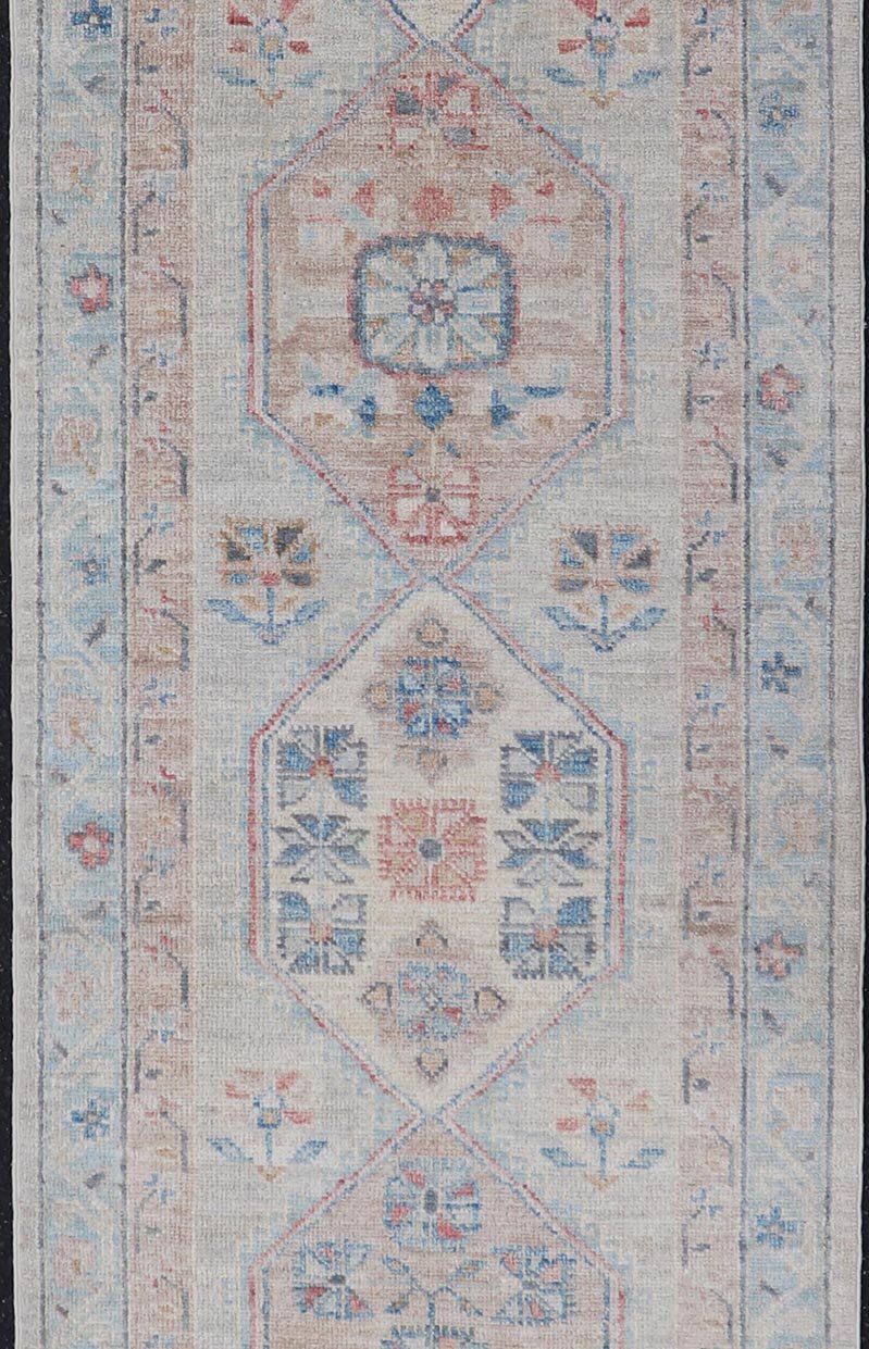 Hand - Knotted Oushak Runner with Medallion Design On A Cream Field With Blues This modern piece holds large medallions in the field, each of which are encasing floral - like motifs. The border is rendered in light blue and coral both embroidere... - Keivan Woven ArtsAWR - 6036 - 19977Rug