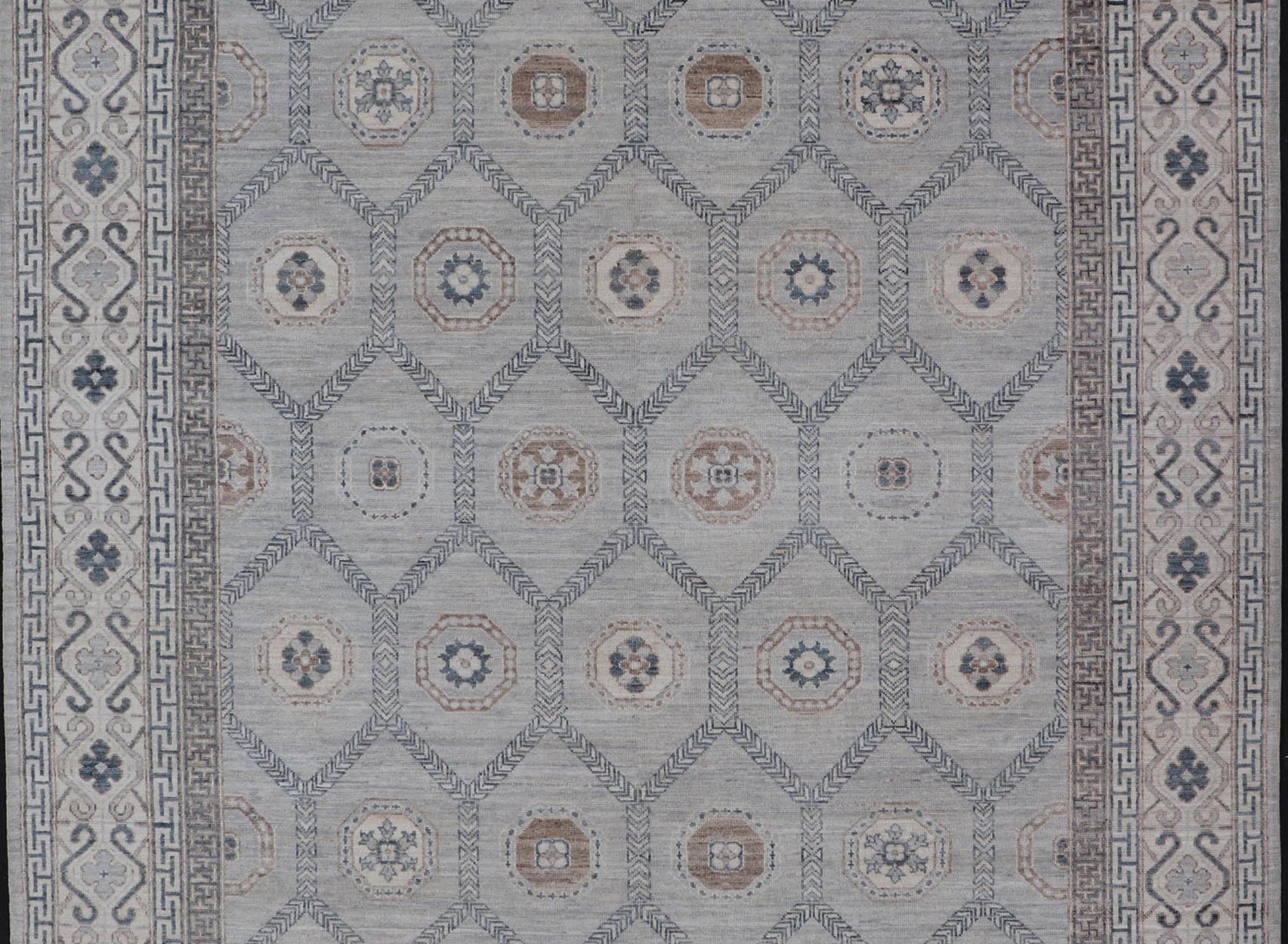 Sub - Geometric Mosaic Khotan Rug With Muted Tones of Blue and Brown This hand - knotted Khotan features geometric medallions, each of which hold a small geometric motif. The border hosts different geometric designs on each tier, alternating between... - Keivan Woven ArtsAWR - 6044 - 19989Rug