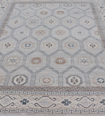 Sub - Geometric Mosaic Khotan Rug With Muted Tones of Blue and Brown This hand - knotted Khotan features geometric medallions, each of which hold a small geometric motif. The border hosts different geometric designs on each tier, alternating between... - Keivan Woven ArtsAWR - 6044 - 19989Rug