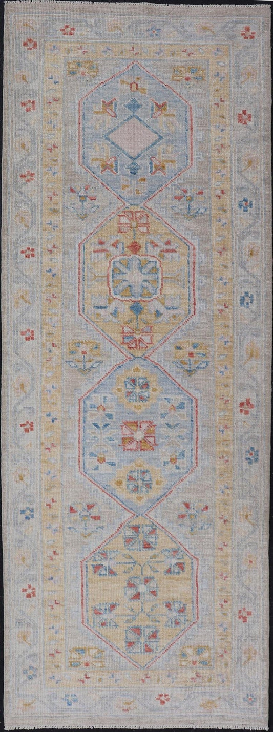 Hand - Knotted Floral Medallion Oushak Runner in Blue and Yellow This piece showcases brilliant medallions encasing star - like motifs in yellow, coral, orange, light blue, and cream. The border displays a yellow band between a cream background.... - Keivan Woven ArtsAWR - 6116 - 20013Rug