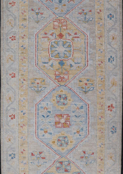 Hand - Knotted Floral Medallion Oushak Runner in Blue and Yellow This piece showcases brilliant medallions encasing star - like motifs in yellow, coral, orange, light blue, and cream. The border displays a yellow band between a cream background.... - Keivan Woven ArtsAWR - 6116 - 20013Rug