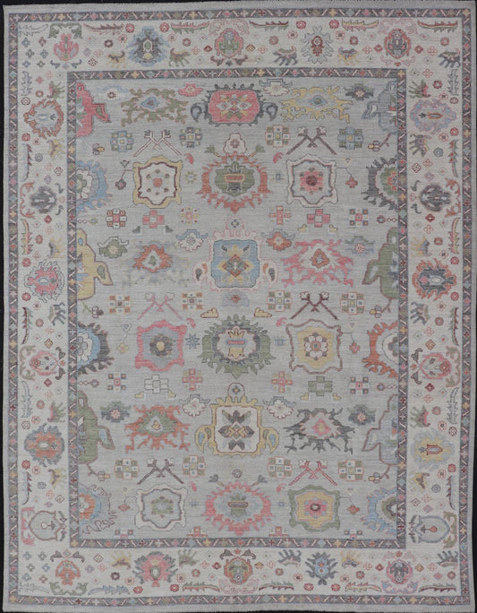 Oushak Floral Motif on Light Grey Background and Colorful Design The border and field are covered in floral - like motifs filled with colors such as pink, green, gold, teal and red - oranges on top of silvery grey background. The border showcases a ... - Keivan Woven ArtsAWR - 6148 - 20025