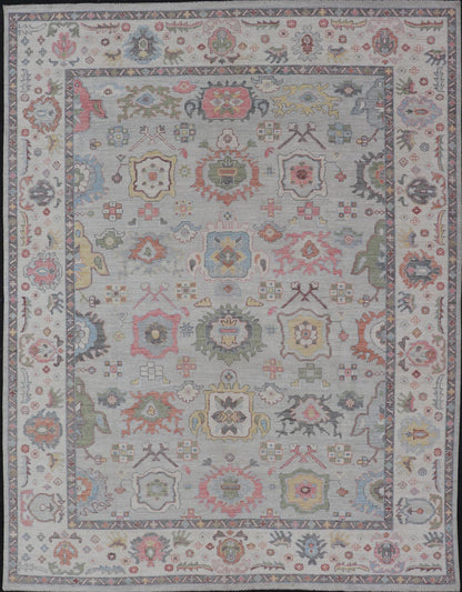 Oushak Floral Motif on Light Grey Background and Colorful Design The border and field are covered in floral - like motifs filled with colors such as pink, green, gold, teal and red - oranges on top of silvery grey background. The border showcases a ... - Keivan Woven ArtsAWR - 6148 - 20025Rug