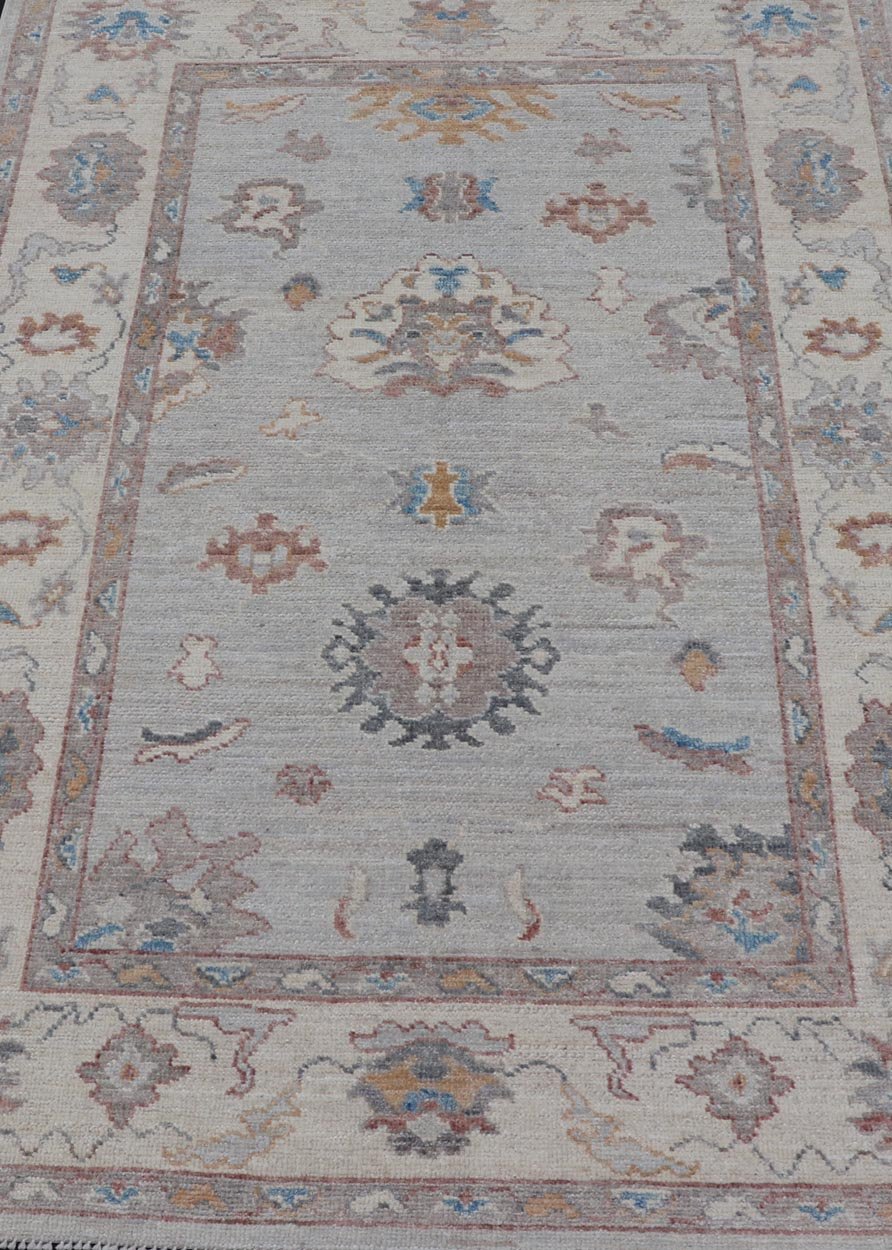 Floral Modern Oushak With Muted Gray Background and Cream Border This piece gives a modern vibrancy to the classic floral Oushak design. With a louder light gray background, the field showcases bold accents of cream and taupe in a half - floral, ... - Keivan Woven ArtsAWR - 6287 - 20031Rug