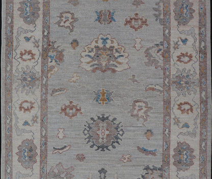 Floral Modern Oushak With Muted Gray Background and Cream Border This piece gives a modern vibrancy to the classic floral Oushak design. With a louder light gray background, the field showcases bold accents of cream and taupe in a half - floral, ... - Keivan Woven ArtsAWR - 6287 - 20031Rug