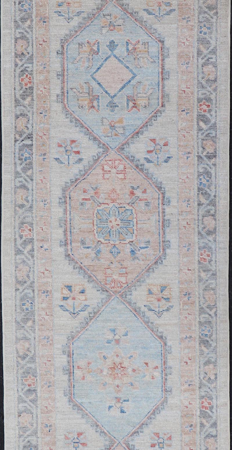 Modern Oushak Medallion Runner in Pastel Color Tones This Afghan Oushak presents a double - lined floral border on top of a light gray background, accenting colors such as blue, red, and salmon. These mix of tones gives a great contrast to many in... - Keivan Woven ArtsAWR - 6290 - 20037Rug