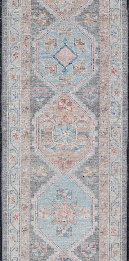 Floral Medallion Oushak Runner With Tribal Motifs and On A Gray Background This Hand - Knotted Afghan Oushak presents a double - lined floral border on top of a dark taupe background, accenting colors such as blue, red, and peach. The field disp... - Keivan Woven ArtsAWR - 6296 - 19905Rug