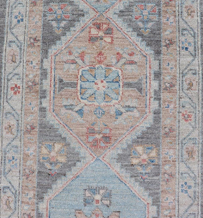 Floral Medallion Oushak Runner With Tribal Motifs and On A Gray Background This Hand - Knotted Afghan Oushak presents a double - lined floral border on top of a dark taupe background, accenting colors such as blue, red, and peach. The field disp... - Keivan Woven ArtsAWR - 6296 - 19905Rug