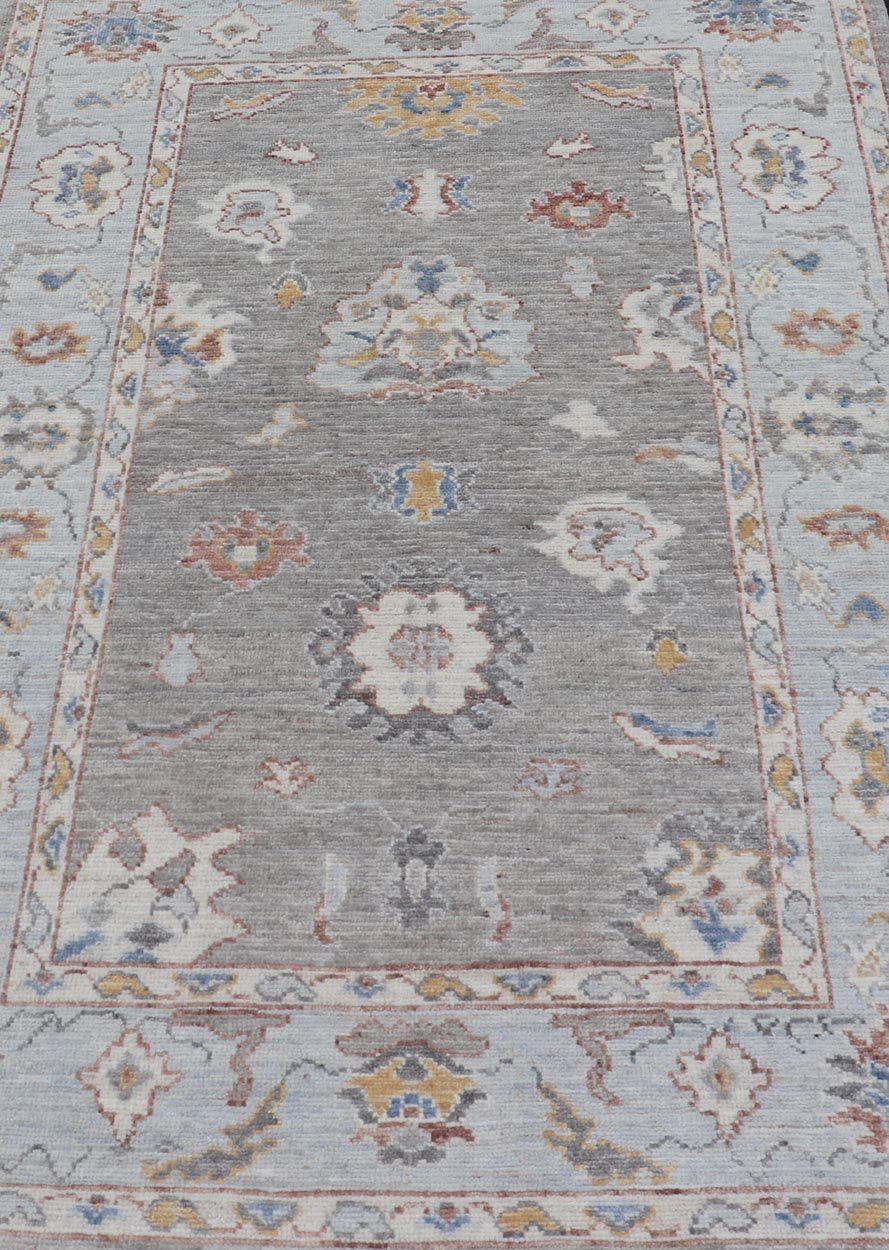 Modern Hand Knotted Oushak with Muted Background and Earthy Accents This beautiful rug starts in a light gray background, paired with a steel blue in the border. The design is an all - over Oushak floral design, highlighting unique colors, su... - Keivan Woven ArtsAWR - 6320 - 20055Rug