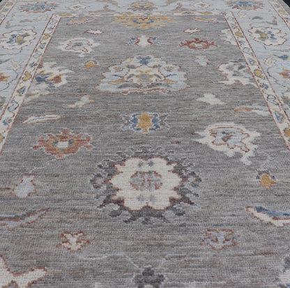 Modern Hand Knotted Oushak with Muted Background and Earthy Accents This beautiful rug starts in a light gray background, paired with a steel blue in the border. The design is an all - over Oushak floral design, highlighting unique colors, su... - Keivan Woven ArtsAWR - 6320 - 20055Rug