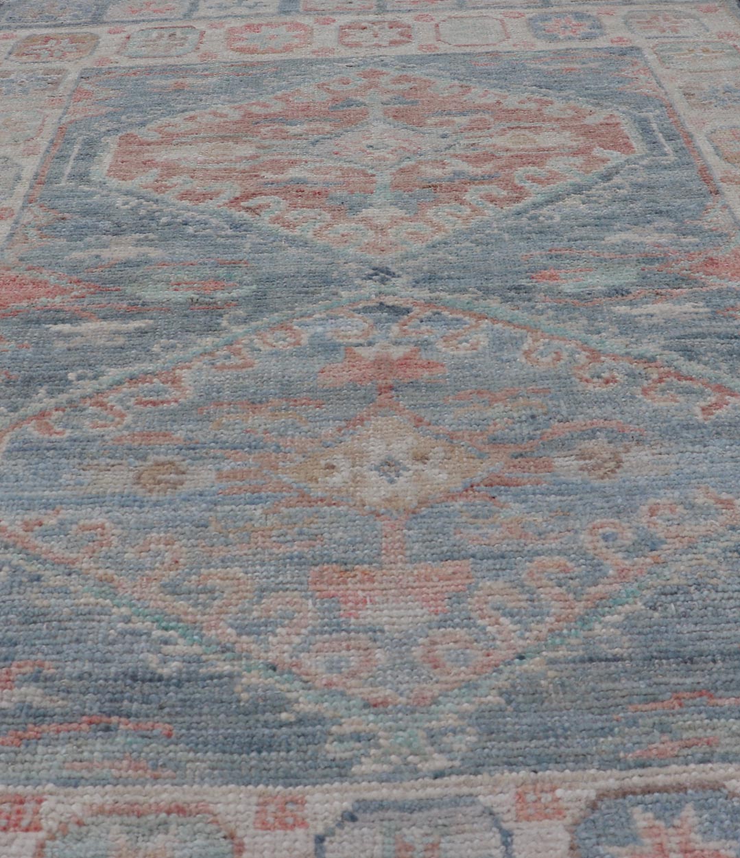 Medallion Designed Modern Oushak with Light Blue Background and Cream Border This modern Oushak features large medallions in the center of a light blue background, centering around shades of blue, coral, and light green. The border features seve... - Keivan Woven ArtsAWR - 6363 - 20073Rug