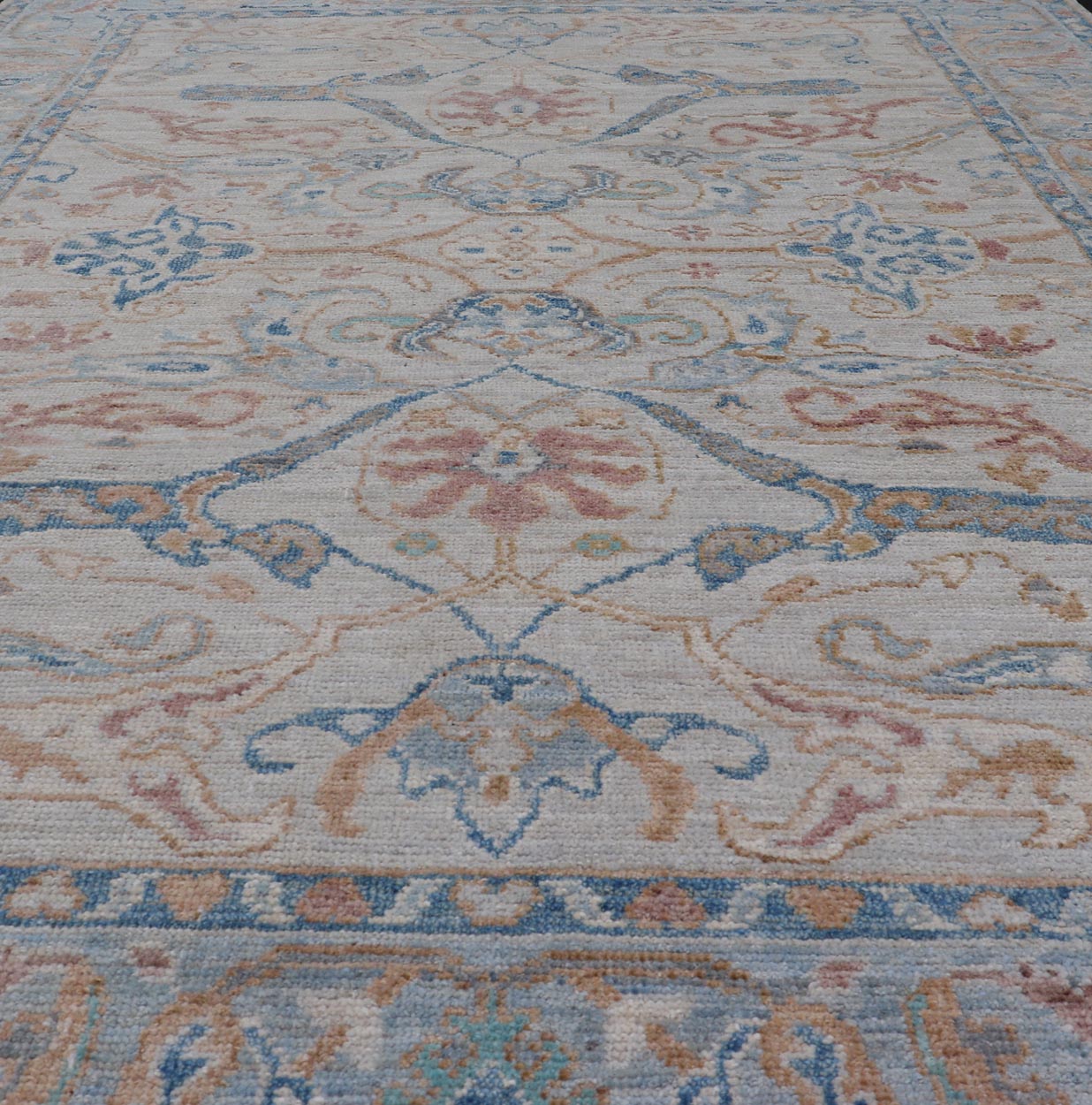Arabesque All - Over Hand Knotted Oushak in Ivory and Blue Tones The field is backed by a ivory color, with a light blue border, etched with elegant golden/brown branches. The arabesque - like design brings splashes of light blue, cognac, and reddis... - Keivan Woven ArtsAWR - 6407 - 20079Rug