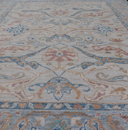 Arabesque All - Over Hand Knotted Oushak in Ivory and Blue Tones The field is backed by a ivory color, with a light blue border, etched with elegant golden/brown branches. The arabesque - like design brings splashes of light blue, cognac, and reddis... - Keivan Woven ArtsAWR - 6407 - 20079Rug