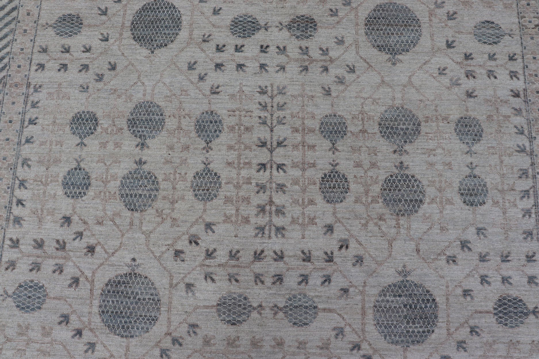 Modern Tribal Khotan Rug In Shades of Cream, Tan, and Light Teal This modern Khotan features a modern muted array of teal, cream, taupe. The background is a beautifully blended cream, topped by an intricate pomegranate design in teal . ... - Keivan Woven ArtsAWR - 8384 - 20836Rug