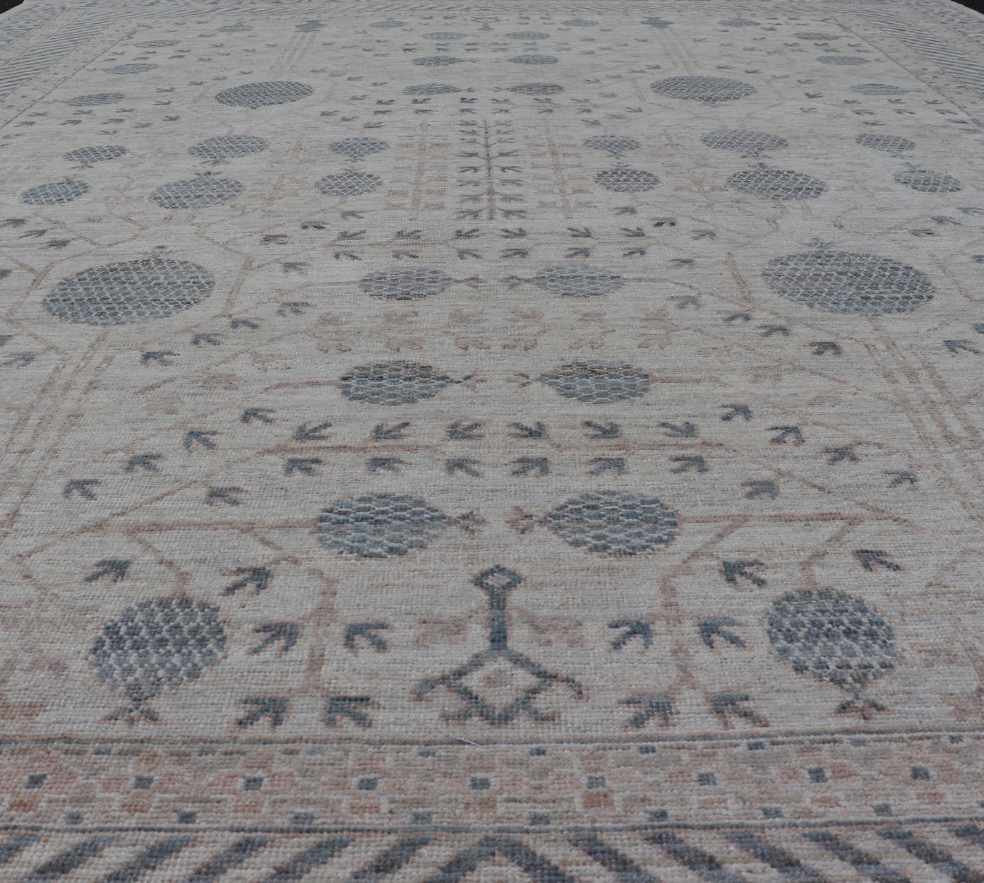 Modern Tribal Khotan Rug In Shades of Cream, Tan, and Light Teal This modern Khotan features a modern muted array of teal, cream, taupe. The background is a beautifully blended cream, topped by an intricate pomegranate design in teal . ... - Keivan Woven ArtsAWR - 8384 - 20836Rug