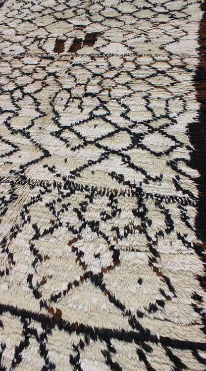 Vintage Moroccan Azilal Rug in White/Cream and Black for Modern Interiors This exquisite piece features a graphic handwoven Berber design with randomly drawn highlights, this piece is packed with motifs and symbols. The white or ivory colors are... - Keivan Woven ArtsBDS - 136622 - 7279Rug