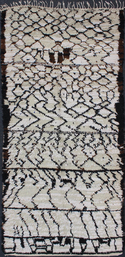 Vintage Moroccan Azilal Rug in White/Cream and Black for Modern Interiors This exquisite piece features a graphic handwoven Berber design with randomly drawn highlights, this piece is packed with motifs and symbols. The white or ivory colors are... - Keivan Woven ArtsBDS - 136622 - 7279Rug