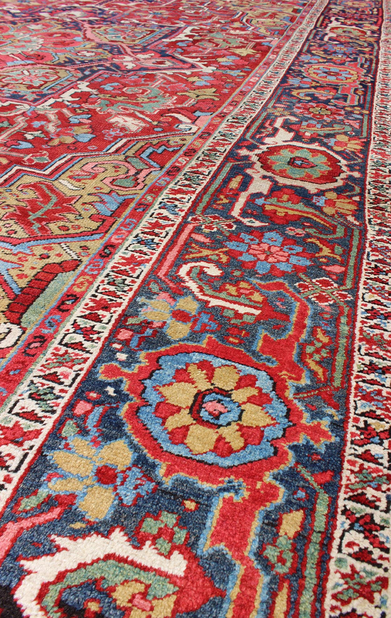 Antique Heriz Carpet with Stylized Floral Motifs and Complementary Border This magnificent antique Persian Heriz carpet from the early 20th century bears an exquisite design rendered in gorgeous, warm hues of red and various shades of blue. A hi... - Keivan Woven ArtsCA - 14882 - 517Rug