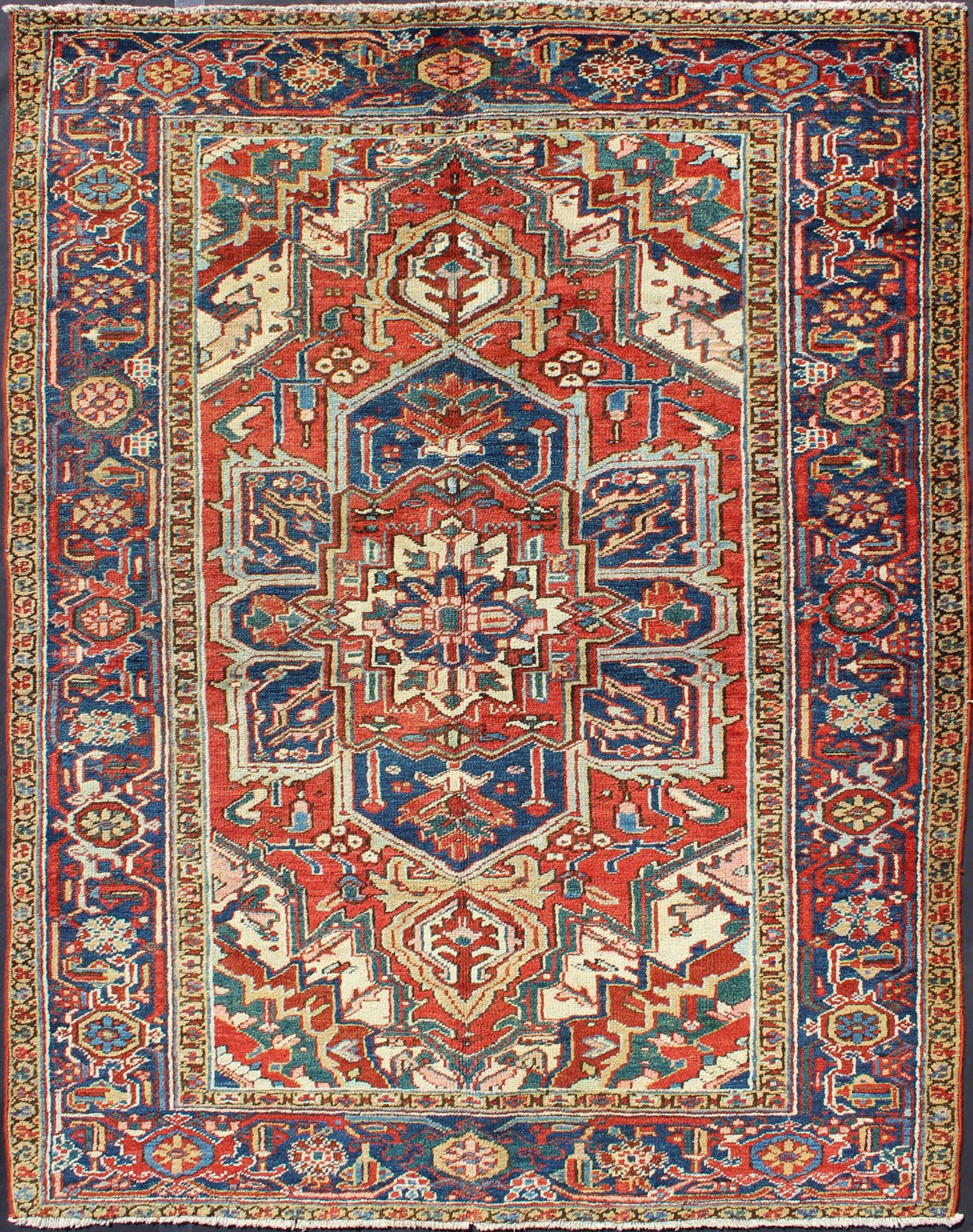Antique Heriz - Serapi Rug This antique Persian Heriz - Serapi from the early 20th century bears an exquisite design rendered in gorgeous, warm hues of red and denim blue. A highly stylized geometric center medallion anchors the piece and is surroun... - Keivan Woven ArtsD - 0908 - 2205Rug