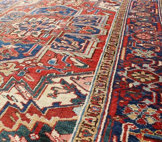 Antique Heriz - Serapi Rug This antique Persian Heriz - Serapi from the early 20th century bears an exquisite design rendered in gorgeous, warm hues of red and denim blue. A highly stylized geometric center medallion anchors the piece and is surroun... - Keivan Woven ArtsD - 0908 - 2205