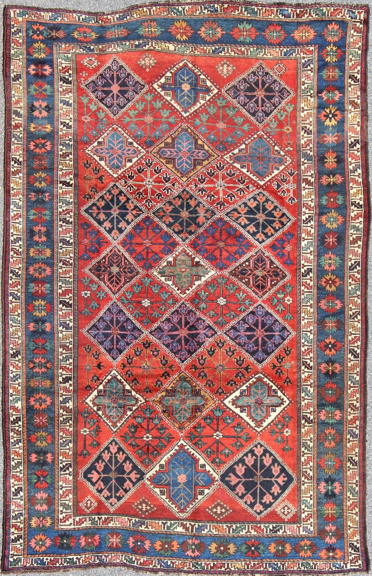 Antique Persian Qashqai Rug with Tulips, Diamond Patterns and Star Motifs This amazing antique Persian Qashqai rug originates from the tribes of southwestern Iran and features a wonderful geometric pattern and traditional color palette. The vari... - Keivan Woven ArtsD - 0909 - 862Rug