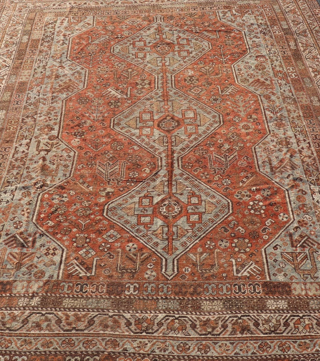 Measures: 7'0 x 10'1 Antique Persian Shiraz Rug With Medallions Geometric in Rusty Orange, Steel Blue. Keivan Woven Arts / rug EMB - 22108 - 15052, country of origin / type: Iran / Shiraz, circa 1920. This antique distressed Persian Shiraz rug (cir... - Keivan Woven ArtsEMB - 22108 - 15052 - 20547Rug