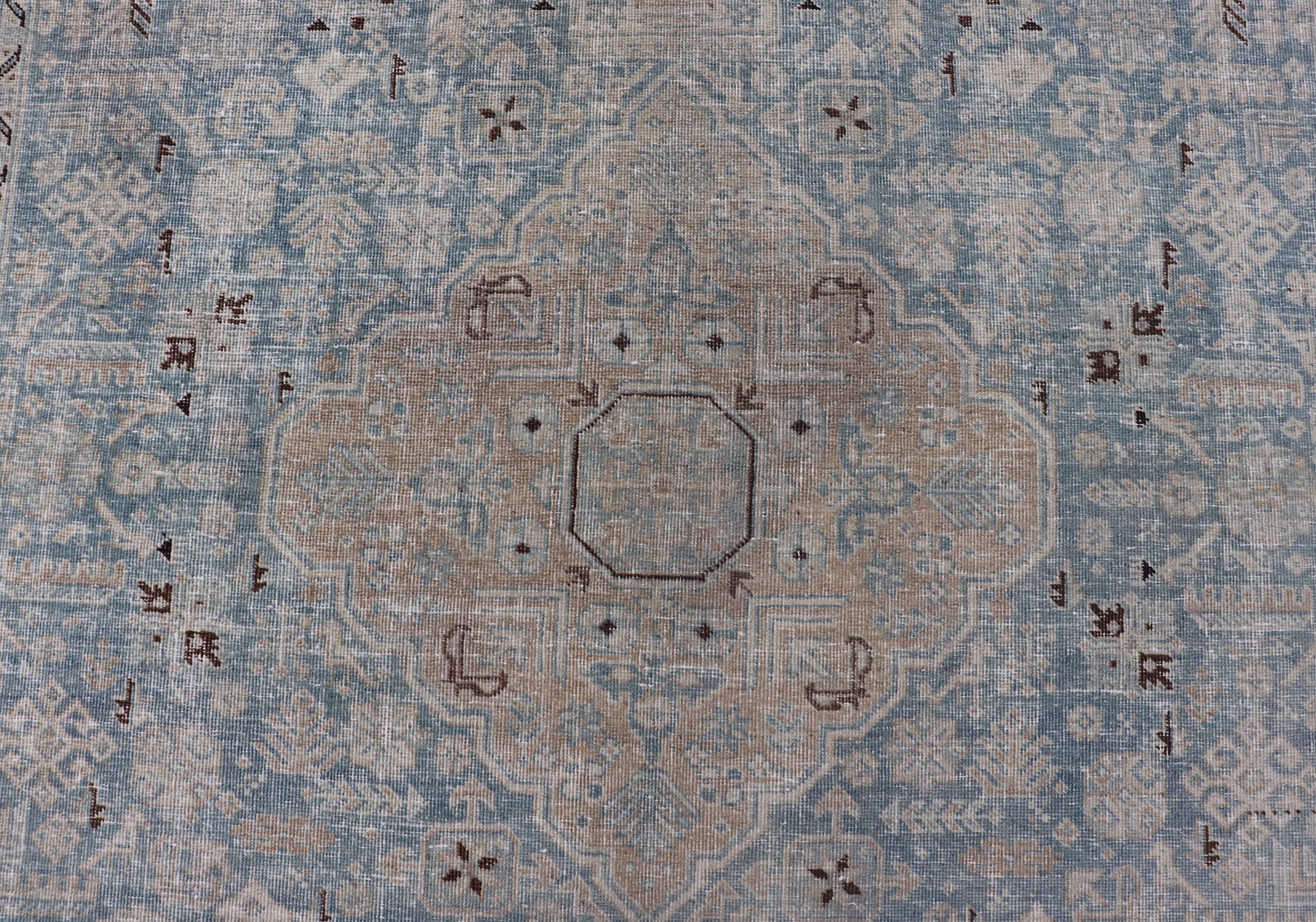 Measures: 6'0 x 9'0 The rug's central field is highlighted by a soft blue background adorned with a detailed medallion pattern in shades of beige and ivory. The design includes various geometric and floral motifs that are arranged symmetrically, cr... - Keivan Woven ArtsEMB - 22236 - 22460Rug