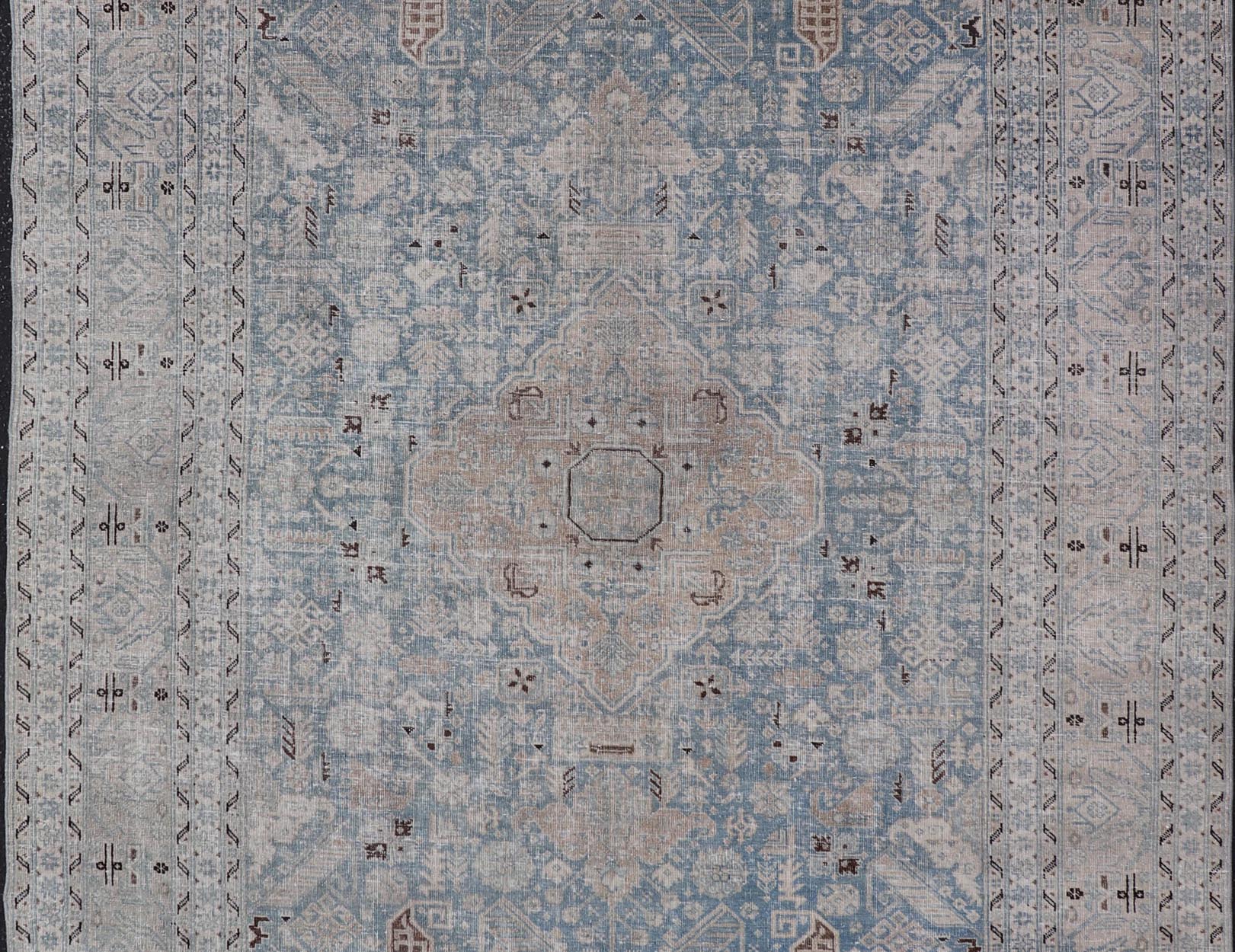Measures: 6'0 x 9'0 The rug's central field is highlighted by a soft blue background adorned with a detailed medallion pattern in shades of beige and ivory. The design includes various geometric and floral motifs that are arranged symmetrically, cr... - Keivan Woven ArtsEMB - 22236 - 22460Rug