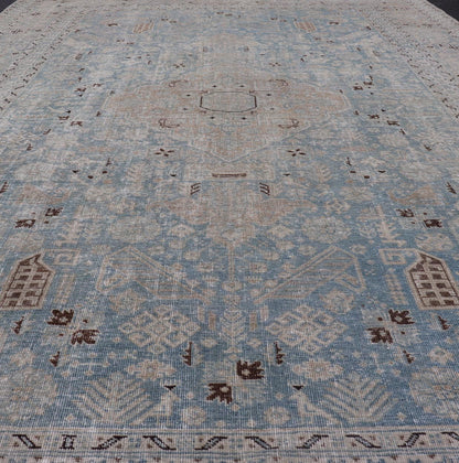 Measures: 6'0 x 9'0 The rug's central field is highlighted by a soft blue background adorned with a detailed medallion pattern in shades of beige and ivory. The design includes various geometric and floral motifs that are arranged symmetrically, cr... - Keivan Woven ArtsEMB - 22236 - 22460