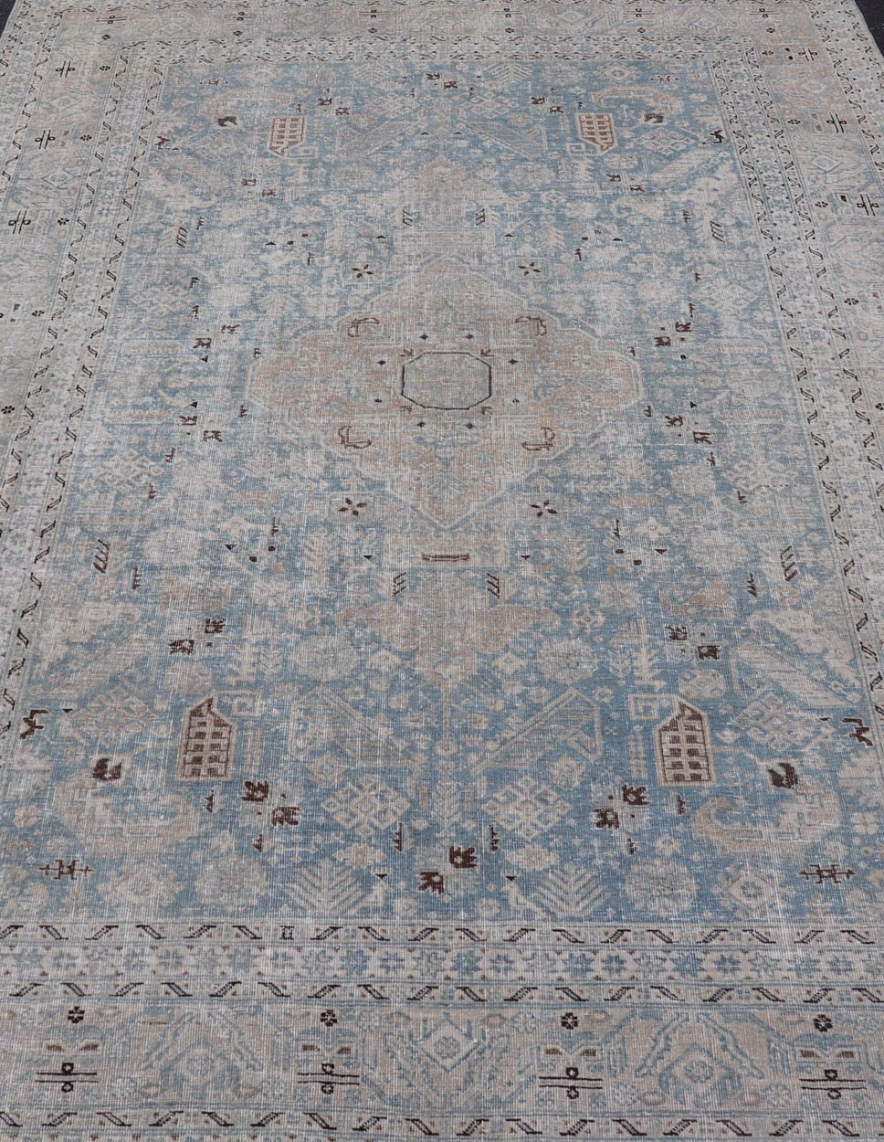 Measures: 6'0 x 9'0 The rug's central field is highlighted by a soft blue background adorned with a detailed medallion pattern in shades of beige and ivory. The design includes various geometric and floral motifs that are arranged symmetrically, cr... - Keivan Woven ArtsEMB - 22236 - 22460Rug