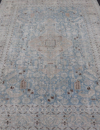 Measures: 6'0 x 9'0 The rug's central field is highlighted by a soft blue background adorned with a detailed medallion pattern in shades of beige and ivory. The design includes various geometric and floral motifs that are arranged symmetrically, cr... - Keivan Woven ArtsEMB - 22236 - 22460Rug
