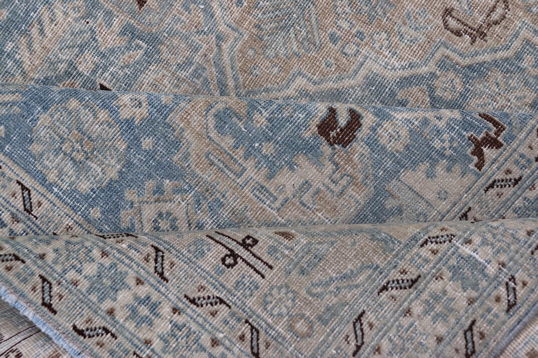Measures: 6'0 x 9'0 The rug's central field is highlighted by a soft blue background adorned with a detailed medallion pattern in shades of beige and ivory. The design includes various geometric and floral motifs that are arranged symmetrically, cr... - Keivan Woven ArtsEMB - 22236 - 22460