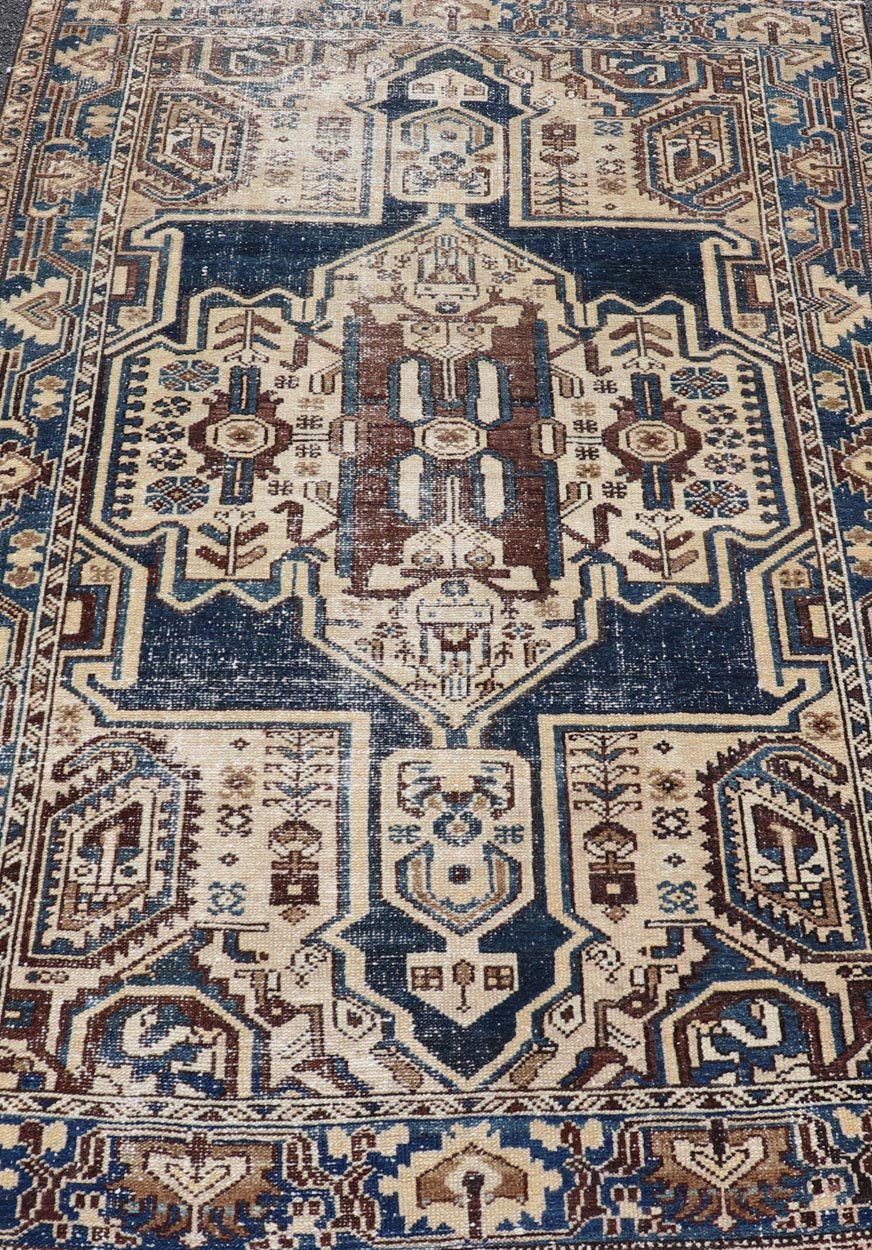 Measures: 4'4 x 6'9 The rug's central field showcases a prominent medallion pattern set against a deep blue background, accented with beige and brown geometric and floral motifs. The medallion itself is highly detailed, featuring a complex arrangem... - Keivan Woven ArtsEMB - 22237 - 22466