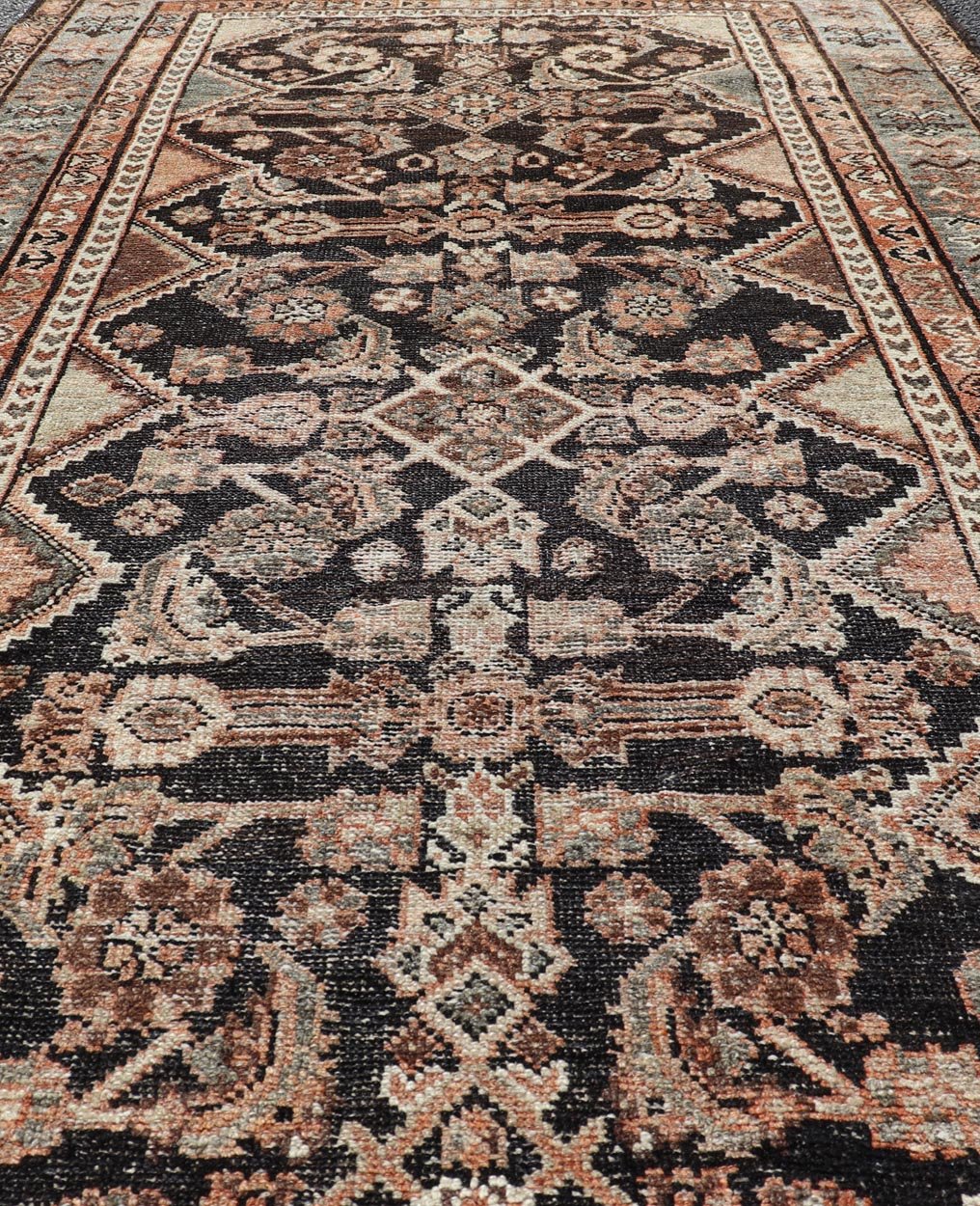 Measures: 3'6 x 6'4 The rug's central field features a dark background adorned with detailed floral and geometric motifs in shades of beige, brown, and soft orange. The design is symmetrical, with a central medallion and repeating patterns that cre... - Keivan Woven ArtsEMB - 22239 - 22478